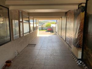um corredor vazio de um edifício com um corredor que conduz a uma entrada em Hostal Español Coyhaique em Coihaique