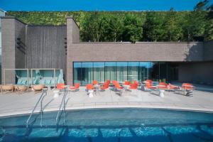 福岡的住宿－Miyako Hotel Hakata，一个带橙色椅子和桌子的游泳池