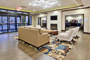 a waiting room with chairs and a fireplace at Holiday Inn Express & Suites Buford NE - Lake Lanier by IHG in Buford