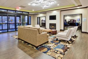 a waiting room with chairs and a fireplace at Holiday Inn Express & Suites Buford NE - Lake Lanier Area, an IHG Hotel in Buford