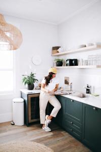 a woman sitting on a counter in a kitchen at The Baxley Bondi in Sydney