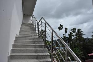 a staircase leading up to a building with palm trees at Wanderers Howff in Port Blair