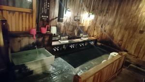 un bagno con vasca e lavandino di Yachi Onsen a Towada