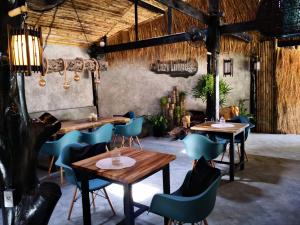 a restaurant with wooden tables and blue chairs at The Lazy Lodge in Ko Lanta