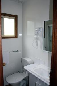 a white bathroom with a toilet and a sink at BIG4 Seymour Holiday Park in Seymour