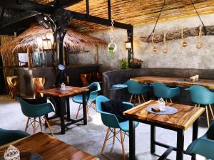 a restaurant with wooden tables and blue chairs at The Lazy Lodge in Ko Lanta