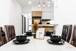 a dining room table with black bowls and chairs at Homestay Meru Ipoh in Ipoh