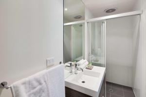 a white bathroom with a sink and a mirror at Drouin Motel in Drouin
