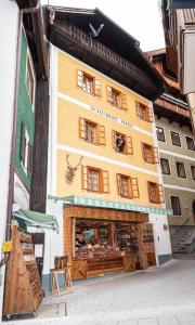 uma loja em frente a um edifício com janelas de madeira em Schubert - Haus em St. Wolfgang