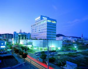 Gumi Century Hotel في كومي: مبنى طويل مع أضواء في مدينة في الليل