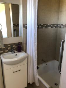 a bathroom with a sink and a shower with a shower curtain at Lavender House in Booroobin +6 photos