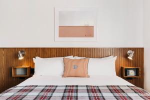 una camera da letto con un letto con un cuscino con la lettera p sopra di Palihotel Culver City a Los Angeles