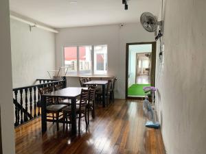 a dining room with tables and chairs and a mirror at Hornbill's Nest Kuching in Kuching