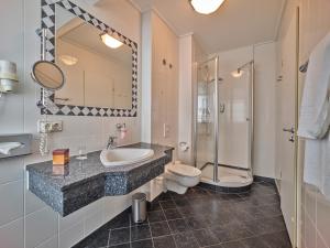uma casa de banho com um lavatório, um WC e um chuveiro em Hotel Tandreas em Giessen