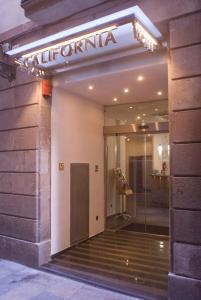 une entrée à un bâtiment avec un panneau sur celui-ci dans l'établissement Hotel California, à Barcelone