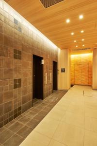 a hallway of a building with a tile wall at Via Inn Prime Shinsaibashi Yotsubashi in Osaka