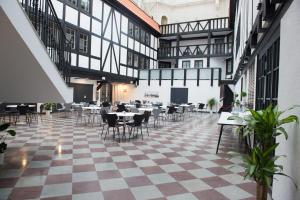 um restaurante com piso em xadrez, mesas e cadeiras em Hotel Stensson em Eslöv