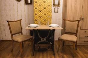 a table with two chairs and a table with two plates on it at Boki Apartmant in Subotica
