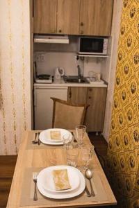 a wooden table with two plates of food on it at Boki Apartmant in Subotica