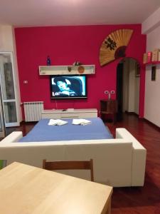 a room with a table and a tv on a wall at Vacanze Romane con giardino in Rome