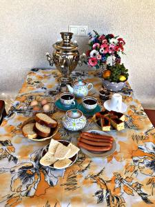 einen Tisch mit einem Tischtuch mit Essen drauf in der Unterkunft Season in Kutaissi