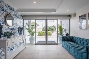 a living room with a blue couch and sliding glass doors at Marina Hotel in Port Lincoln