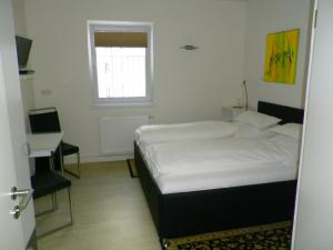 een slaapkamer met een bed, een bureau en een raam bij Astra Hotel in Kaiserslautern