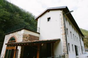 a white building with a balcony on top of it at Locanda Al Confin - Osteria Le Piere in Pigozzo