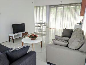sala de estar con 2 sofás y TV en Villa Golf Syariah, en Bandung