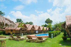 a resort with a swimming pool and straw huts at AoNang Bamboo Pool Resort in Ao Nang Beach