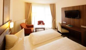 a hotel room with a bed and a desk at allgäu resort in Bad Grönenbach