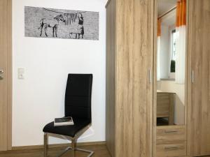 una silla negra en una habitación con una pintura en la pared en zollwanger - Wohnen auf Zeit, en Dilinga