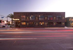 un bâtiment situé sur le côté d'une rue la nuit dans l'établissement Palihotel Melrose, à Los Angeles
