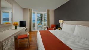 a hotel room with a large bed and a television at Amari Phuket in Patong Beach