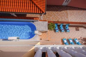 a view of a swimming pool with two blue chairs at Villa Oleander in Dramalj