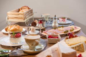 a table topped with plates of food and cups of coffee at Apartments Mooshof in Neustift im Stubaital