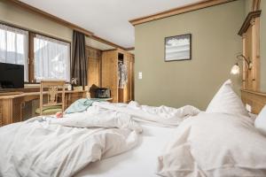 1 dormitorio con 1 cama grande con sábanas blancas en Hotel Sieghard Zillertal, en Mayrhofen