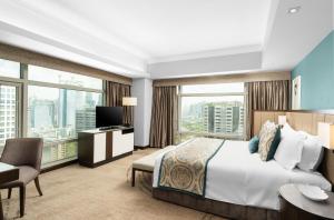 a hotel room with a bed and a large window at Ascott Makati in Manila +79 photos