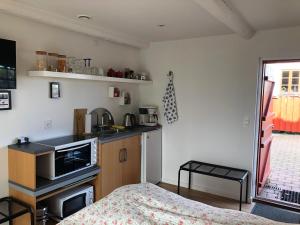 uma pequena cozinha com uma cama num quarto em Bulbrovejs Bed & Breakfast em Havdrup