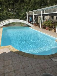 a large swimming pool with a bridge over it at L'Escale Royale in Salazie