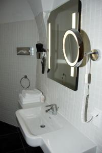 a white bathroom with a sink and a mirror at Gasthof Ludl in Groß-Enzersdorf