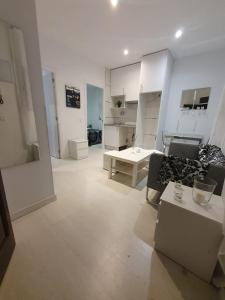 Habitación blanca con sofá y mesa en Marques de Goya Apartaments TPH, en Madrid