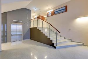 a staircase in a house with a glass railing at Grand Apartments - Neptun Park. in Gdańsk
