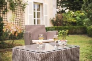 a table with two glasses of white wine on it at La Villa Ribière in Auxerre +38 photos