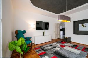 een woonkamer met een blauwe stoel en een tv bij Apartment Andreas in Bolzano