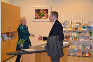 a man and a woman standing at a counter in a pharmacy at Christian Jensen Kolleg und Gästehäuser in Breklum