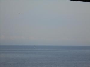 una vista del océano con un barco a lo lejos en Titi Sedana Homestay en Amed