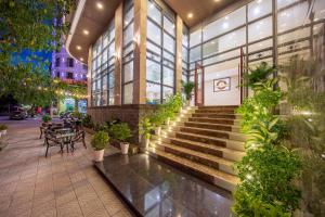 a building with stairs and plants in front of it at Kiwi Beachside Hotel & Cafe Da Nang in Danang