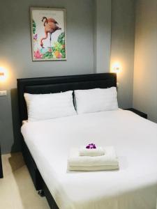 Un dormitorio con una cama blanca con una flor. en HARRYS RESIENDENCE, en Bangkok