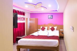 um quarto com uma cama e uma parede rosa em Sree Comforts em Kushalanagar